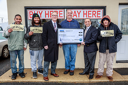 Freeholder Thomas A. Arnone (fifth from left) is joined by Neptune City Councilman Joseph Zajack (third from left) to present Ivan Ferro (fourth from left), owner of A Lot of Cars Auto Sales, with a Façade Improvement Program grant check for $1,815 on March 4, 2016 in Neptune City, NJ.